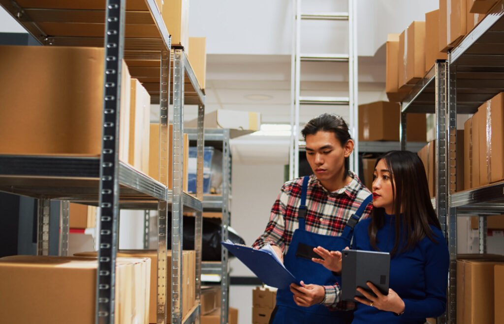 asian employees checking warehouse supplies on tablet